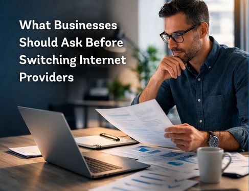 Business owner reviewing documents and laptop while evaluating options before switching business internet providers