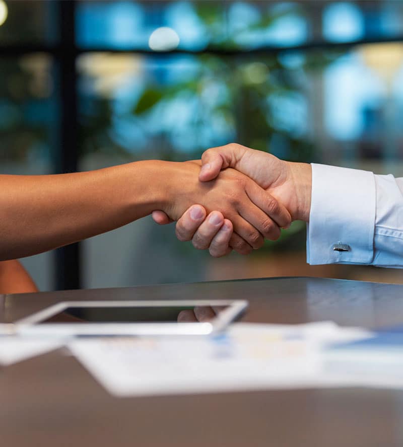 people handshaking at desk